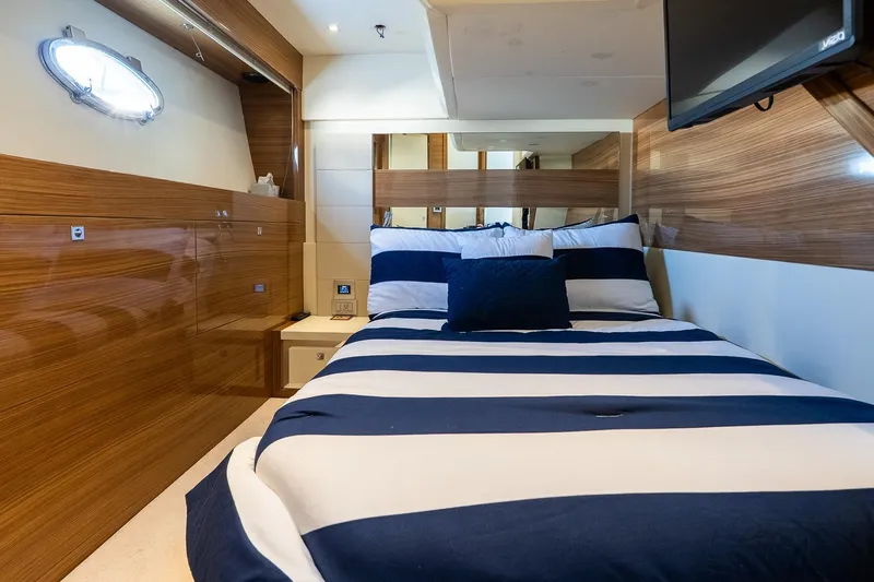 Balliamo Yacht Photos Pics Luxurious cabin interior of 2011 Uniesse 55S yacht with striped bedding and wood paneling.