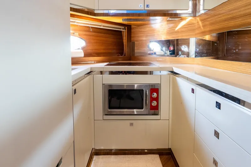 Balliamo Yacht Photos Pics Modern kitchen interior on 2011 Uniesse 55S yacht with wood accents and built-in appliances.