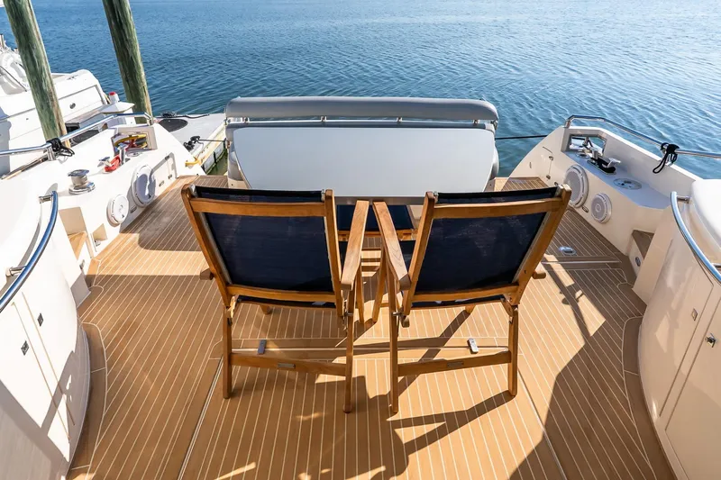 Balliamo Yacht Photos Pics Deck of 2011 Uniesse 55S yacht with wooden chairs overlooking the water.