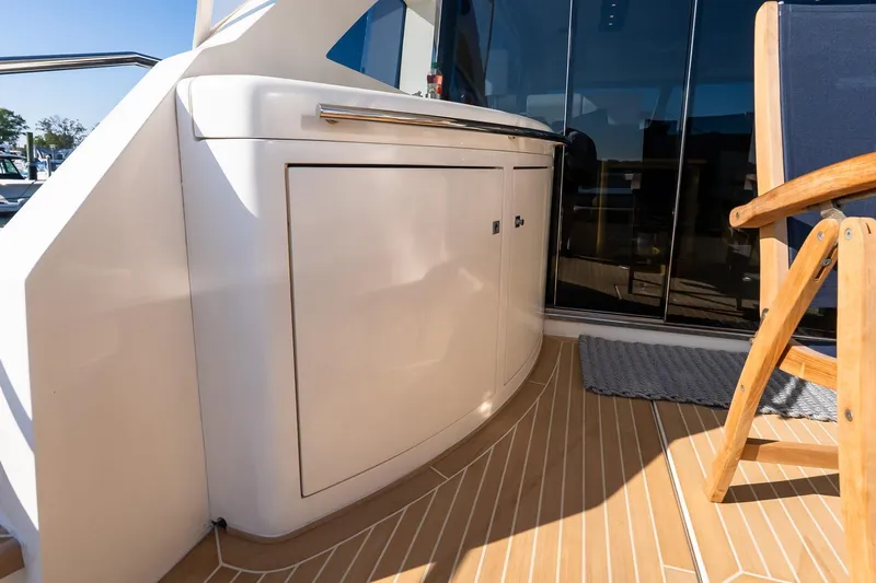Balliamo Yacht Photos Pics 2011 Uniesse 55S yacht deck with sleek cabinetry and wooden chair.
