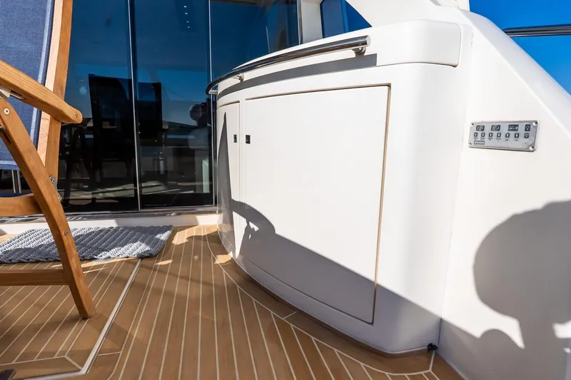 Balliamo Yacht Photos Pics Luxury yacht Uniesse 55S 2011 deck with wooden chair and sleek cabinetry.