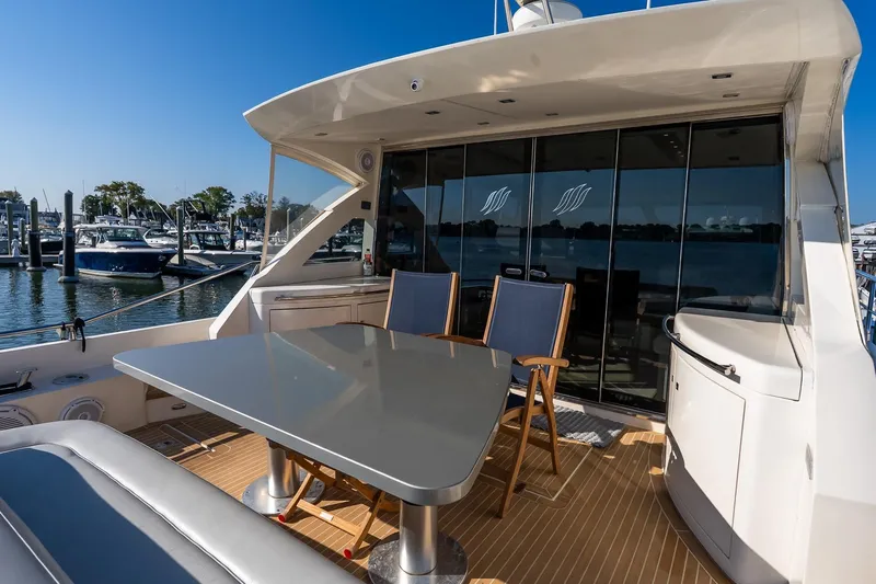 Balliamo Yacht Photos Pics Luxury Uniesse 55S yacht deck with seating and table, docked at marina, 2011 model.