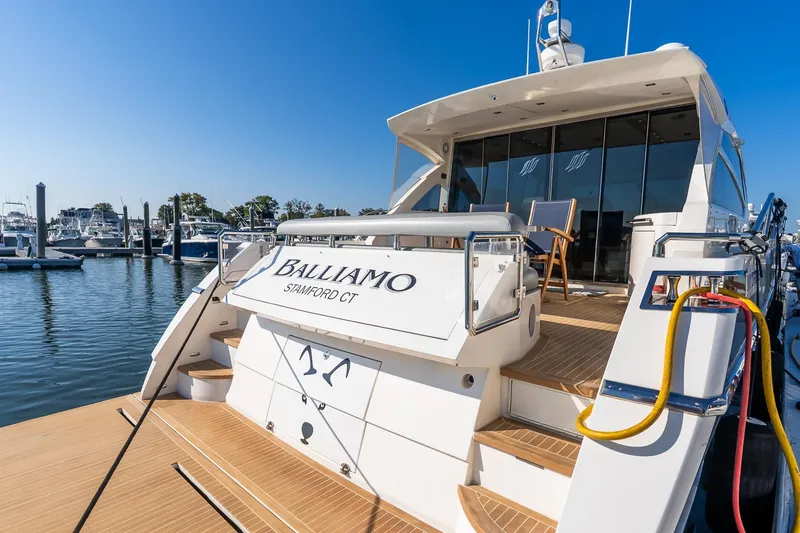 Balliamo Yacht Photos Pics Luxury 2011 Uniesse 55S yacht docked at marina under clear blue sky.