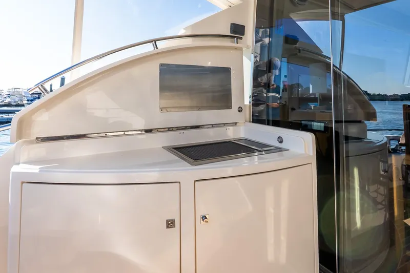 Balliamo Yacht Photos Pics Outdoor kitchen area on a 2011 Uniesse 55S yacht, featuring a grill and storage.