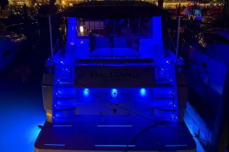 Balliamo Yacht Photos Pics 2011 Uniesse 55S yacht illuminated with blue lights at night in a marina.