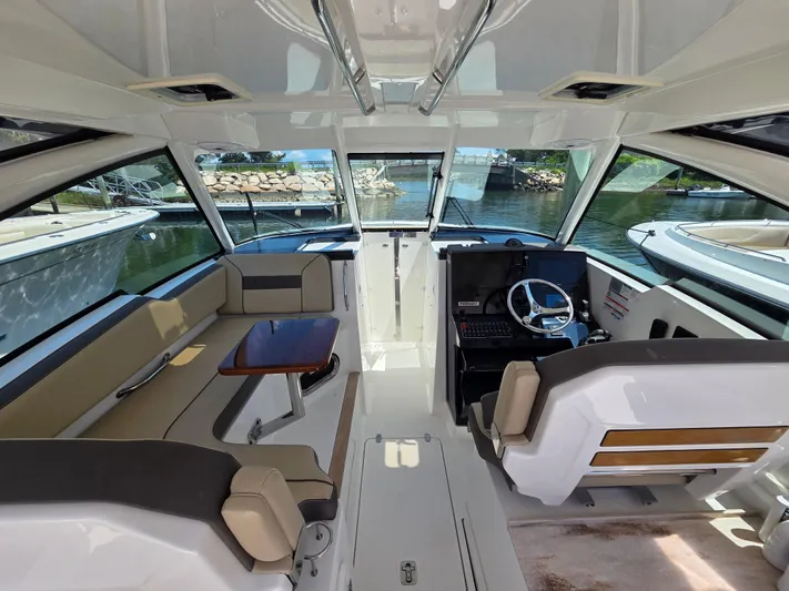 First Mate Yacht Photos Pics 2020 Pursuit DC 326 Dual Console interior with seating and helm, docked by the water.