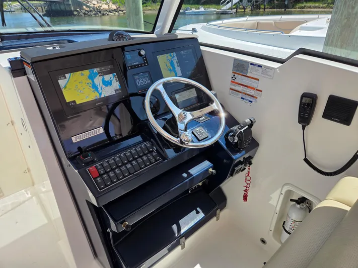 First Mate Yacht Photos Pics 2020 Pursuit DC 326 Dual Console helm with navigation screens and steering wheel.