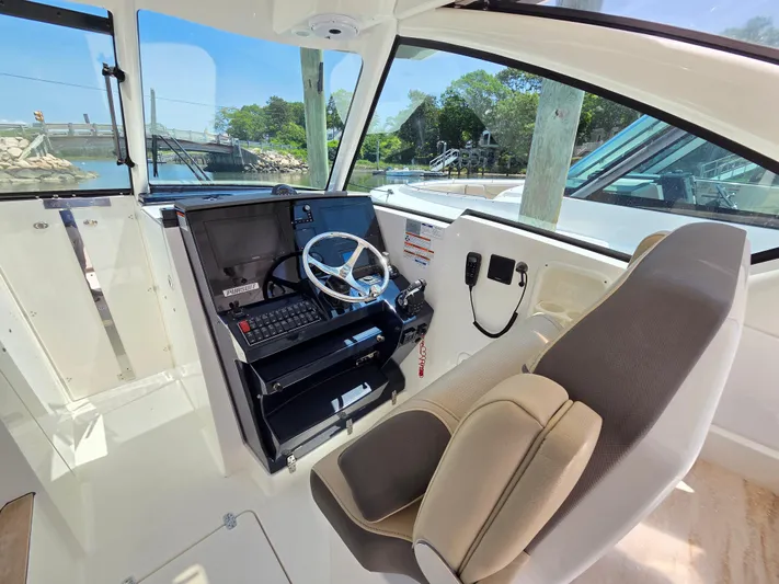 First Mate Yacht Photos Pics 2020 Pursuit DC 326 Dual Console boat interior with steering wheel and control panel.