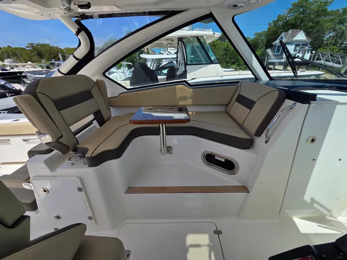 First Mate Yacht Photos Pics 2020 Pursuit DC 326 Dual Console interior with beige seating and compact table.