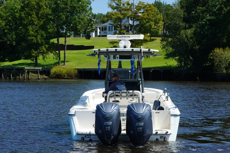 Tagged Yacht Photos Pics 2023 Sea Born LX26 Center Console boat on a scenic river with lush greenery.