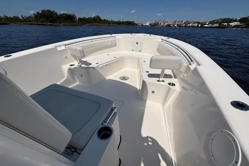Tagged Yacht Photos Pics 2023 Sea Born LX26 Center Console boat interior on calm water, showcasing seating and design.