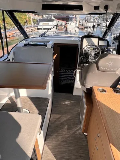  Yacht Photos Pics Interior of 2020 Jeanneau NC 895 boat, featuring helm, seating, and table.