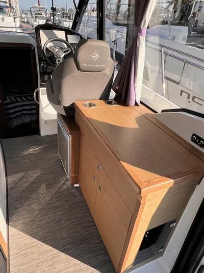  Yacht Photos Pics Interior of 2020 Jeanneau NC 895 boat with helm and wooden cabinetry.
