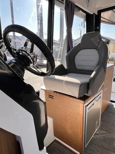  Yacht Photos Pics 2020 Jeanneau NC 895 boat interior with steering wheel and captain's chair.