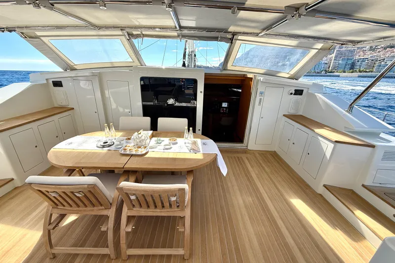  Yacht Photos Pics Luxurious Dereli S/Y 39 m yacht deck with dining area, ocean view, and elegant wood finish.