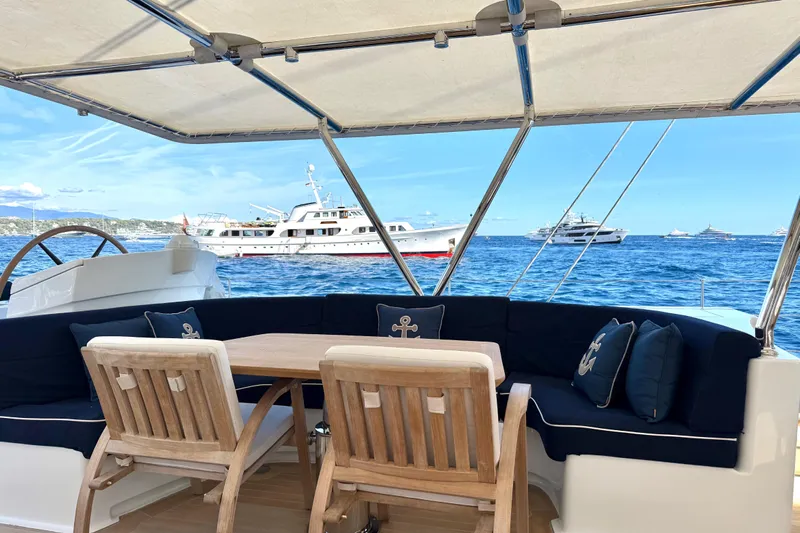  Yacht Photos Pics Luxurious Dereli S/Y 39 m yacht deck with seating, ocean view, and anchored boats, 2004 model.