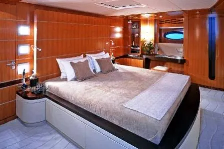  Yacht Photos Pics Luxurious yacht bedroom with modern design, featuring a large bed and elegant wood paneling.