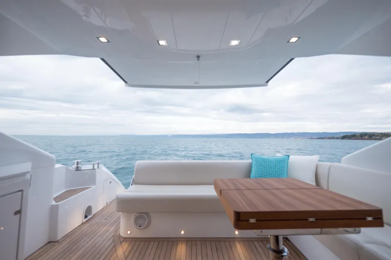Filippetti S55 Yacht Photos Pics Luxurious 2025 Filippetti Sport 55 yacht interior with ocean view, featuring elegant seating and wooden table.