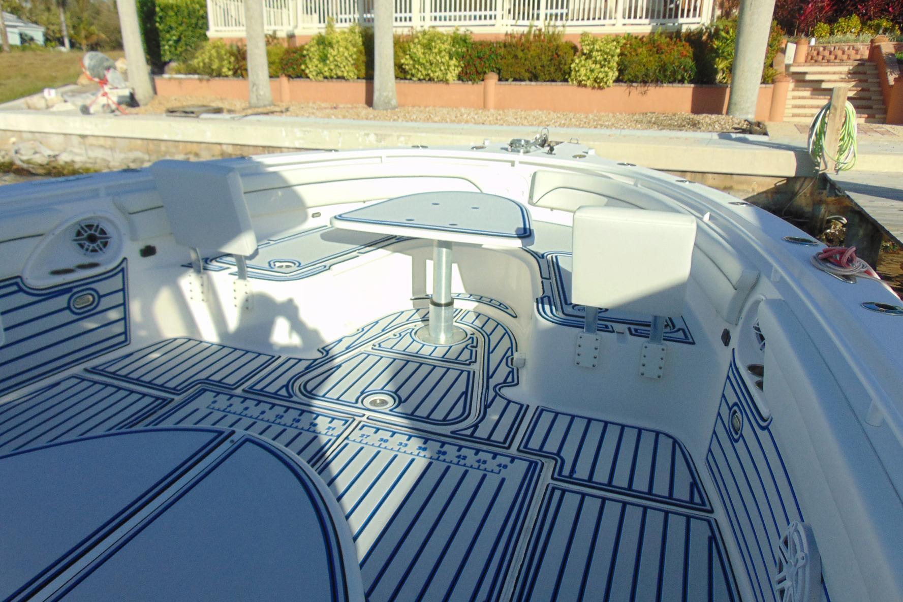 2019 Stamas 390 Tarpon boat interior with seating and table, docked near a garden.
