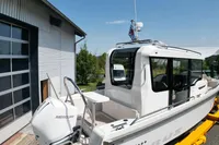 2021 Nimbus C8 boat with Mercury engine, docked near a modern building.