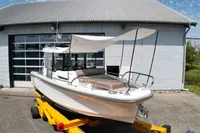 2021 Nimbus C8 boat on trailer outside a garage, featuring a canopy.