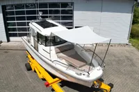 2021 Nimbus C8 boat on trailer, featuring a sunshade, parked outside a garage.