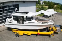 2021 Nimbus C8 boat on yellow trailer, parked outside a garage.
