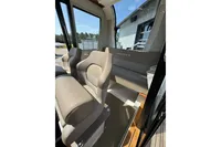 Interior of 2021 Nimbus C8 boat with beige seating and large windows.