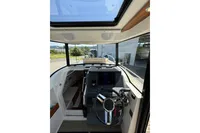 Interior view of 2021 Nimbus C8 boat cockpit with steering wheel and dashboard.