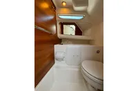 Compact bathroom in 2021 Nimbus C8 boat, featuring wooden paneling and modern fixtures.