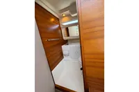 Compact wooden bathroom interior in 2021 Nimbus C8 boat, featuring a toilet and sink.