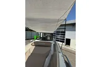 2021 Nimbus C8 boat with canopy, docked near a building.