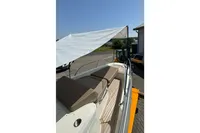 2021 Nimbus C8 boat with canopy, featuring cushioned seating and sleek design.