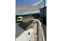 2021 Nimbus C8 boat with sunshade, featuring cushioned seating and wooden deck.