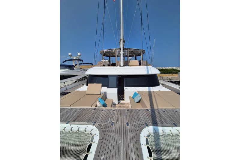 Alemys Yacht Photos Pics 2023 Sunreef 50 yacht with spacious deck and sun loungers, under clear blue sky.