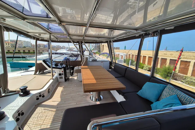 Alemys Yacht Photos Pics Luxurious Sunreef 50 yacht interior with spacious seating and wooden table, 2023 model.