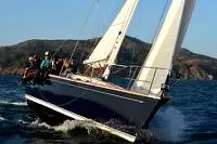 Escapade Yacht Photos Pics Sailing Sabre 402 yacht from 1997 on open water with crew onboard.