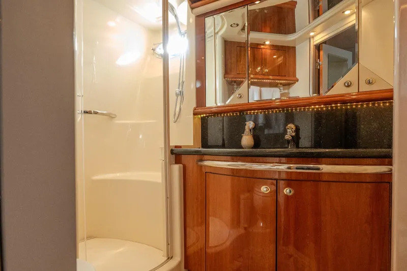  Yacht Photos Pics Luxurious bathroom in 2003 Sea Ray 680 Sun Sport yacht with wood cabinetry and modern fixtures.