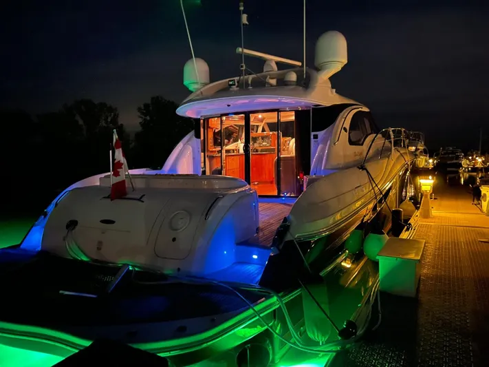  Yacht Photos Pics Luxurious 2003 Sea Ray 680 Sun Sport yacht illuminated at night with vibrant green and blue lights.