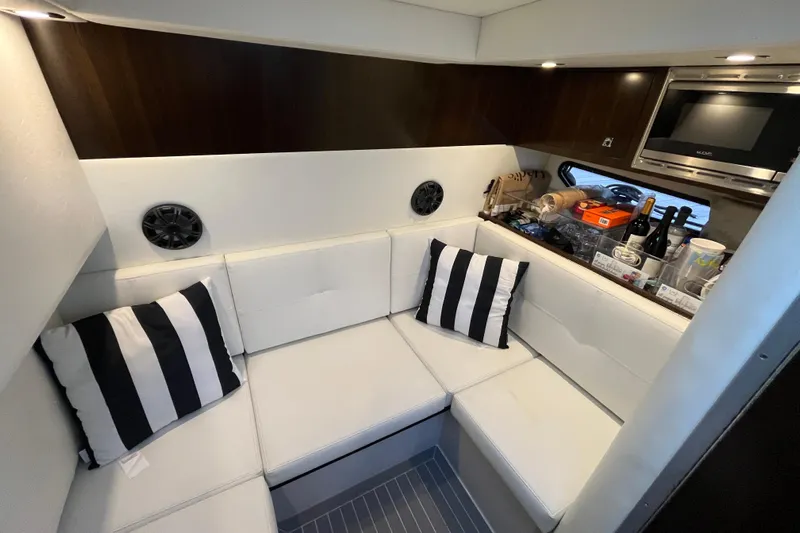  Yacht Photos Pics 2022 Cruisers Yachts 338 South Beach Edition interior with white seating and striped pillows.