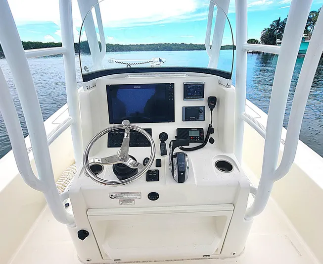  Yacht Photos Pics 2017 SeaVee 270Z boat console with steering wheel, navigation screens, and controls on calm water.