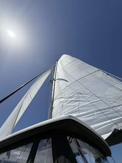 No Schedule Yacht Photos Pics Lagoon 42 Owners Version 2019 sailboat with sails unfurled against a clear blue sky.