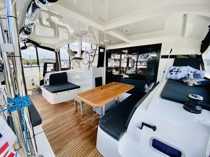 No Schedule Yacht Photos Pics 2019 Lagoon 42 Owners Version catamaran with spacious cockpit, wooden table, and comfortable seating.