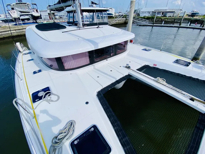 No Schedule Yacht Photos Pics 2019 Lagoon 42 Owners Version catamaran docked at marina, showcasing sleek design and spacious deck.