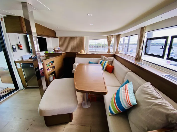 No Schedule Yacht Photos Pics Spacious interior of 2019 Lagoon 42 Owners Version catamaran with modern seating and colorful cushions.