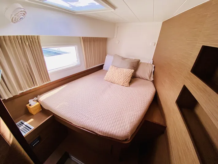 No Schedule Yacht Photos Pics 2019 Lagoon 42 Owners Version cabin with cozy bed, window, and wooden interior.