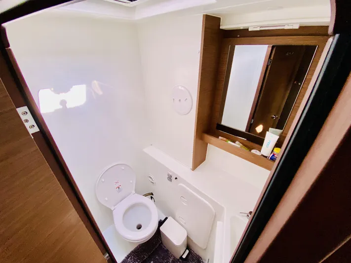 No Schedule Yacht Photos Pics Bathroom interior of 2019 Lagoon 42 Owners Version yacht, featuring toilet and mirror.
