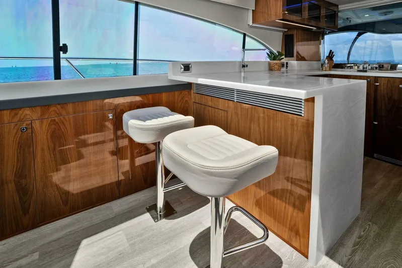 Gia Yacht Photos Pics Luxurious interior of 2021 Riviera 5400 Sport Yacht with modern bar stools and ocean view.