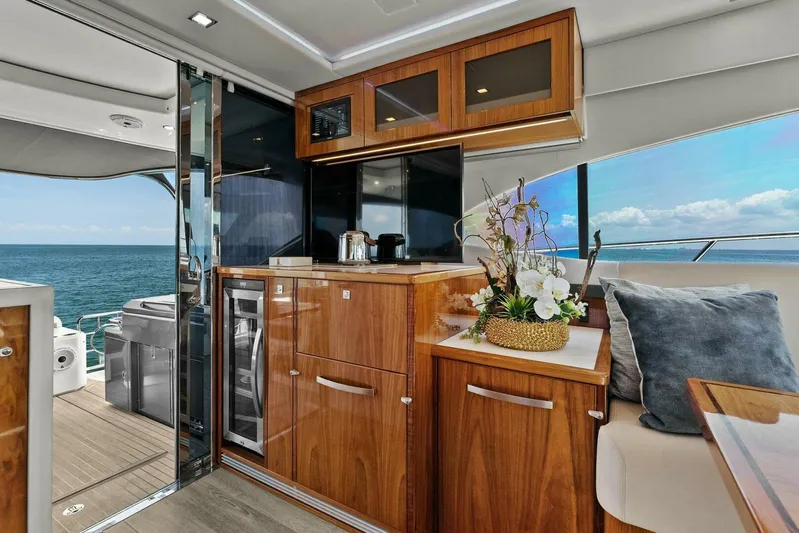 Gia Yacht Photos Pics 2021 Riviera 5400 Sport Yacht interior with elegant wood cabinetry and ocean view.