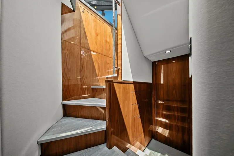 Gia Yacht Photos Pics Interior staircase of 2021 Riviera 5400 Sport Yacht with wooden paneling and modern design.